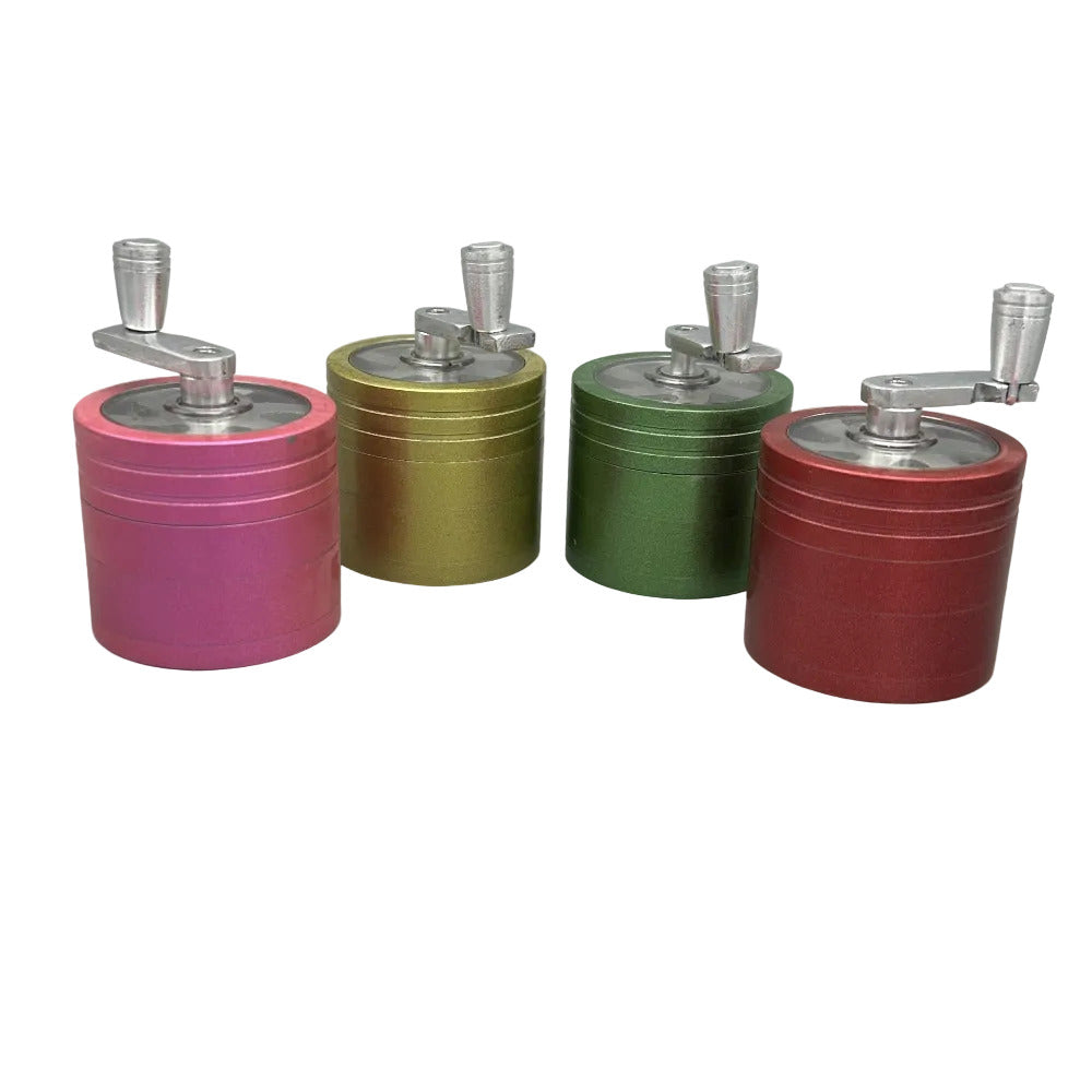 Four colorful spice grinders with metal handles on a gray background